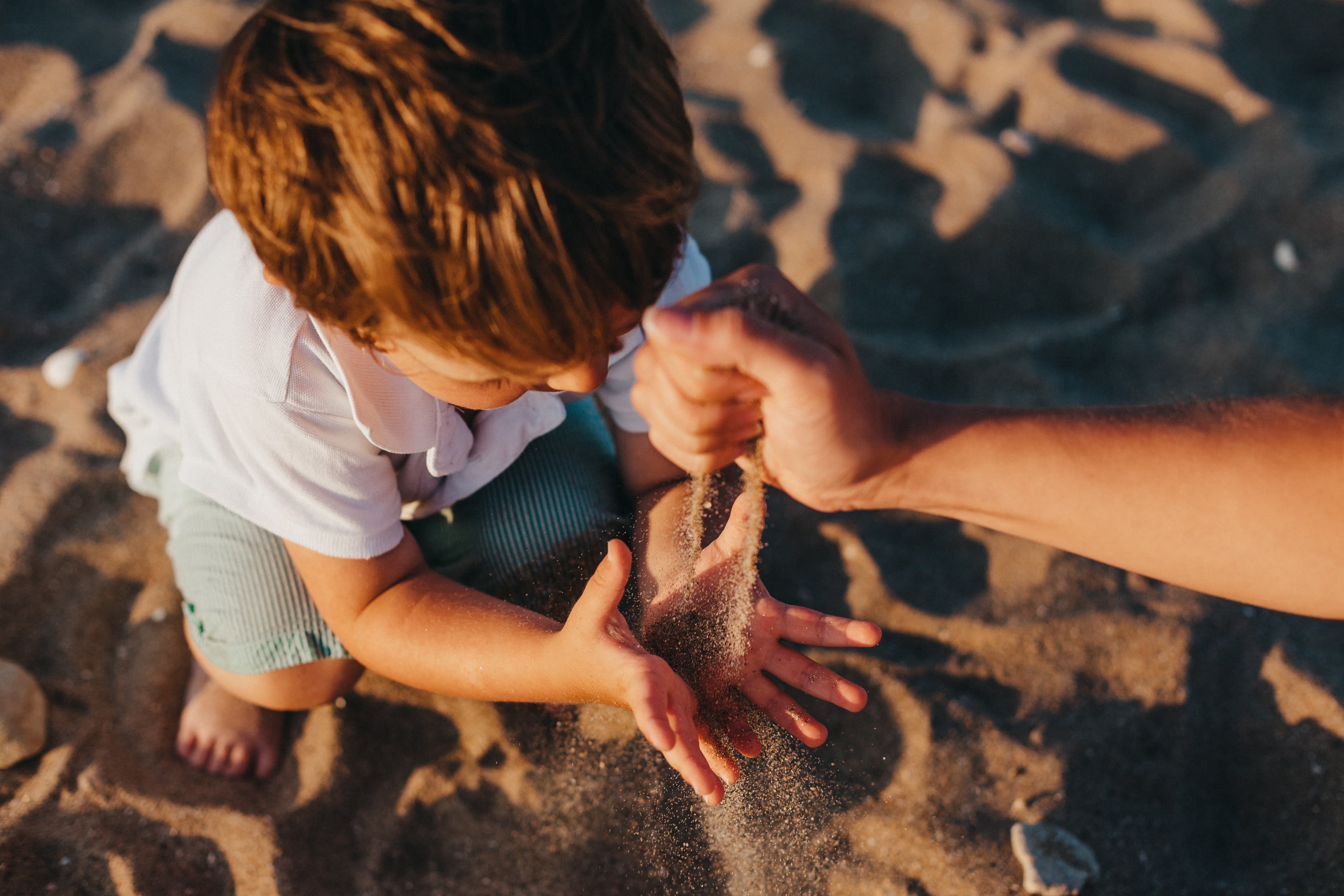Un enfant et un adulte jouent ensemble avec du sable